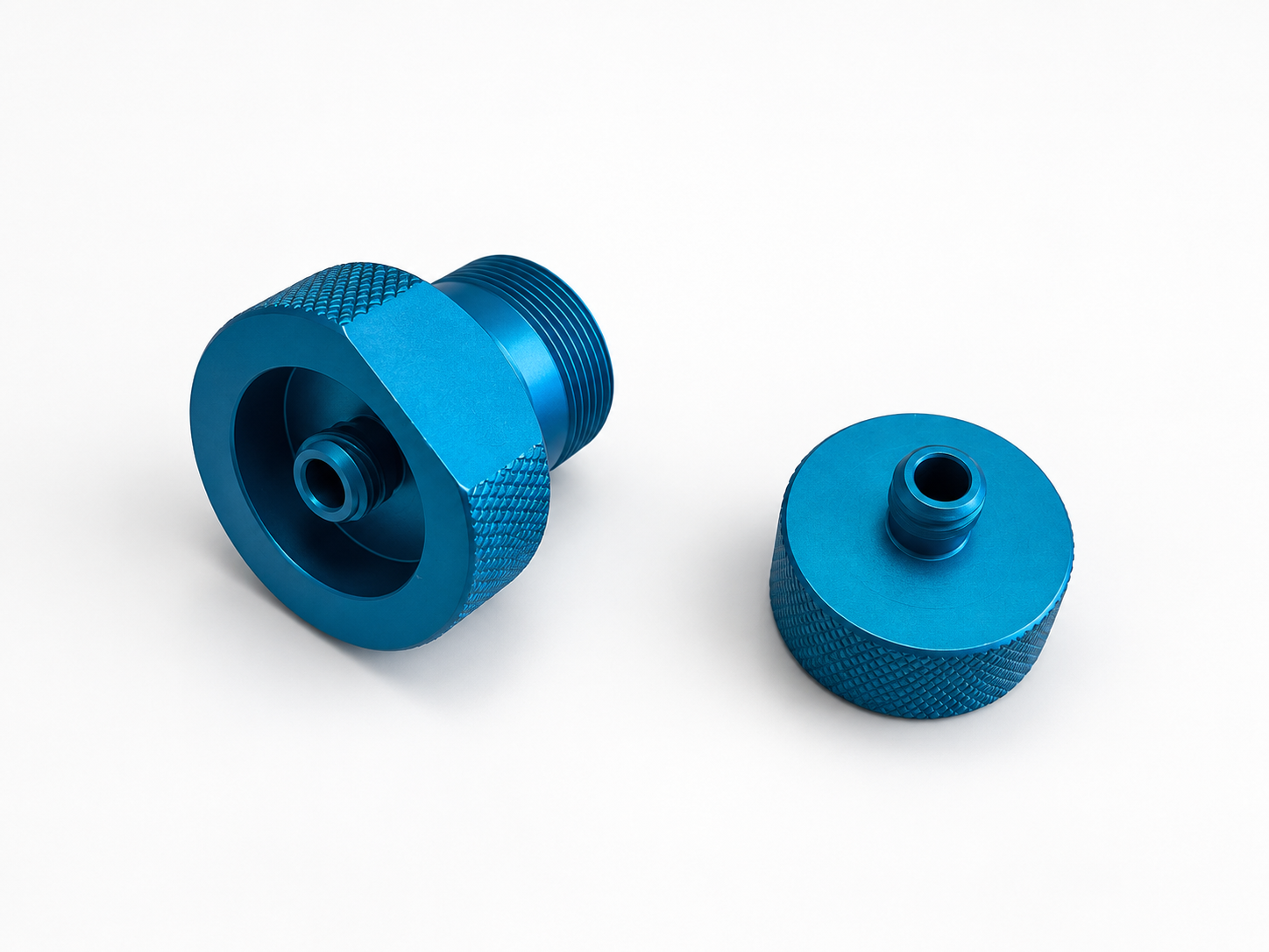 Raccords Luer usinés en aluminium avec finition anodisée bleue.